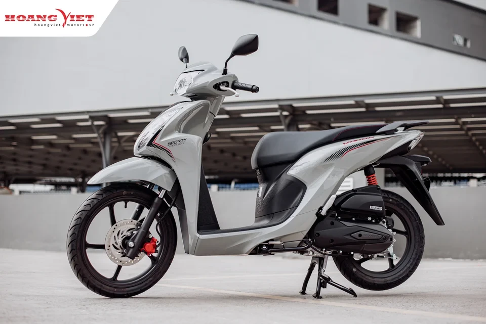 Đế kích thủy lực đang được luồn vào khoảng sáng gầm hẹp của chiếc xe tay ga nhỏ trên nền gạch phẳng