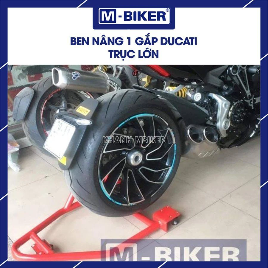 Cốt trục kim loại được luồn qua lỗ trục bánh sau xe mô tô gắp đơn để chuẩn bị kích nâng